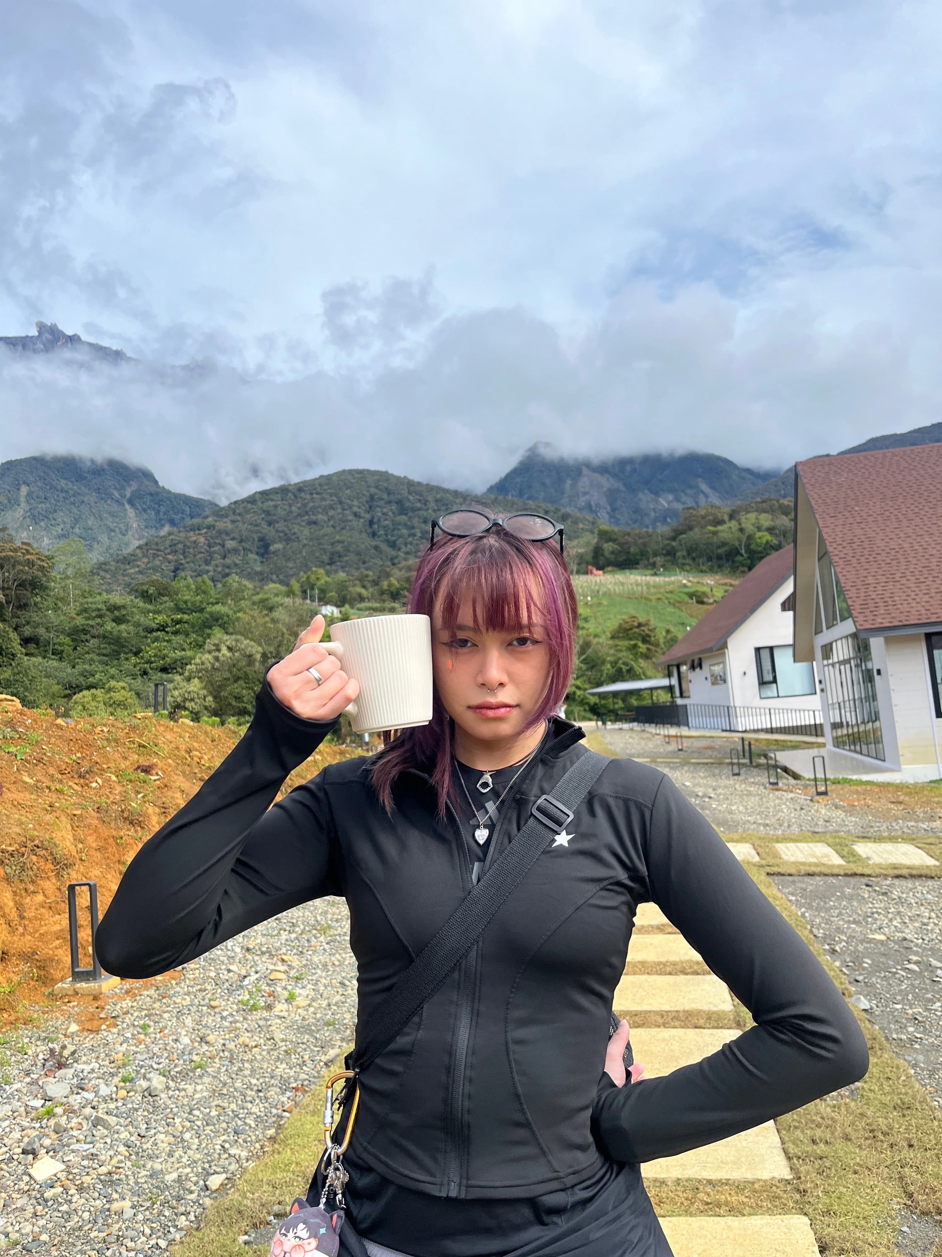Syazlynn holding a cup outdoors